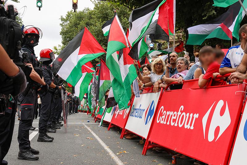 Manifestantes propalestinos despues de empujar las vallas en la recta final de la etapa en Bilbao, desatando momentos de tensión que obligaron a neutralizar la carrera.